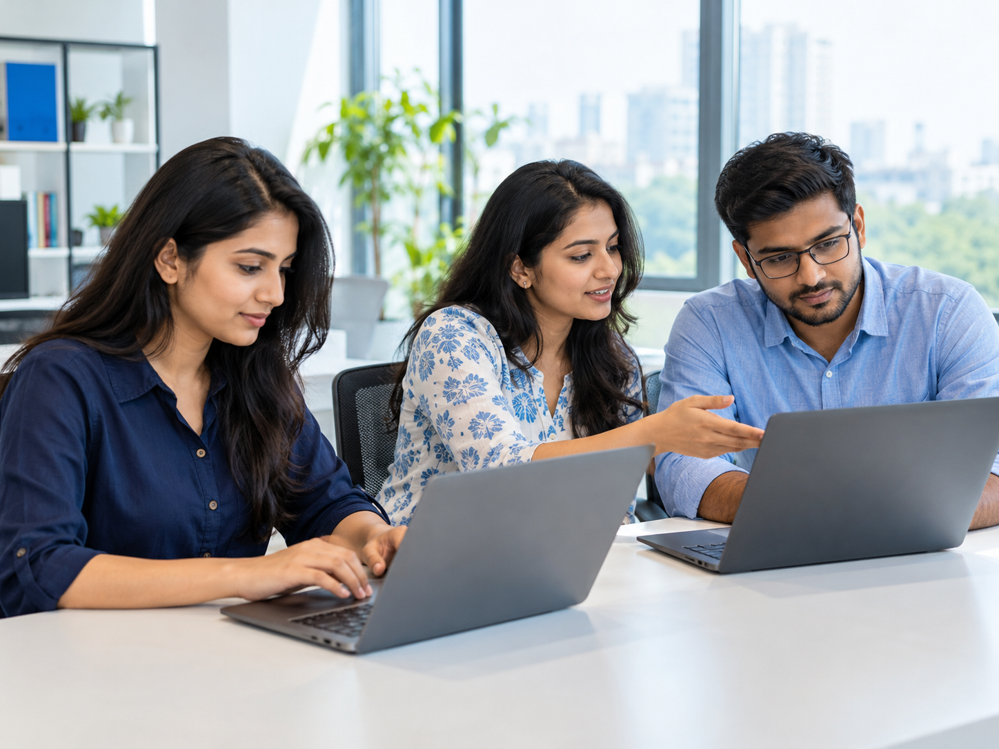 Indian professionals working on laptops in a modern office